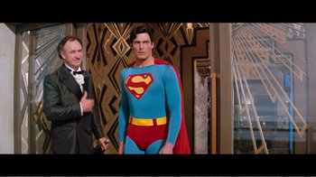 Movie still from “Superman IV: The Quest for Peace” (1987), directed by Sidney J. Furie – A man in a superman costume standing next to a man in a suit; Medium shot, Over the shoulder angle