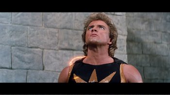 Movie still from “Superman IV: The Quest for Peace” (1987), directed by Sidney J. Furie – A man in a black and gold shirt looking up; Close Up shot, Low angle