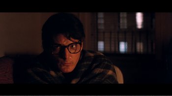 Movie still from “Superman IV: The Quest for Peace” (1987), directed by Sidney J. Furie – A man wearing glasses sitting in a chair with a blanket; Close Up shot, Over the shoulder angle