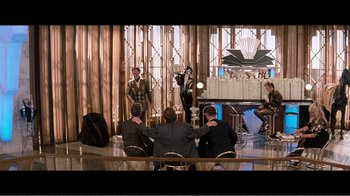 Movie still from “Superman IV: The Quest for Peace” (1987), directed by Sidney J. Furie – A group of people sitting around a table; Wide shot, Over the shoulder angle