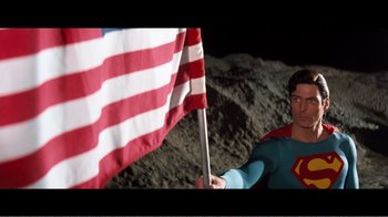 Movie still from “Superman IV: The Quest for Peace” (1987), directed by Sidney J. Furie – A man in a superman costume holding a flag; Medium shot, Overhead angle