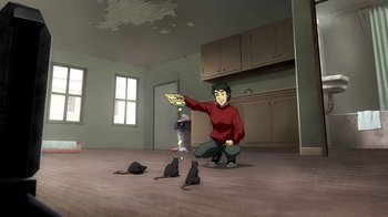 Movie still from “Superman/Shazam!: The Return of Black Adam” (2010), directed by Joaquim Dos Santos – A man sitting on the floor with three cats; Wide shot, High angle