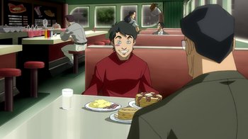 Movie still from “Superman/Shazam!: The Return of Black Adam” (2010), directed by Joaquim Dos Santos – A man sitting in front of plates of food in a restaurant; Medium shot, Over the shoulder angle