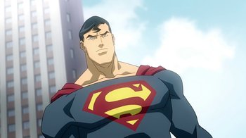 Movie still from “Superman/Shazam!: The Return of Black Adam” (2010), directed by Joaquim Dos Santos – A man in a superman costume standing in front of a building; Medium shot, Low angle