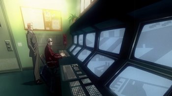 Movie still from “Superman/Shazam!: The Return of Black Adam” (2010), directed by Joaquim Dos Santos – A man sitting in front of a computer monitor; Wide shot, Low angle