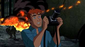 Movie still from “Superman: Doomsday” (2007), directed by Bruce Timm – A man holding up a camera in front of a fire background; Close Up shot, High angle
