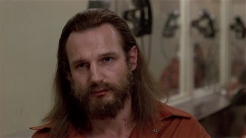 Movie still from “Suspect” (1987), directed by Peter Yates – A person with long hair and a beard; Close Up shot, Over the shoulder angle