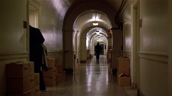 Movie still from “Suspect” (1987), directed by Peter Yates – People walking in a hallway with boxes on the ground; Extreme Wide shot, High angle