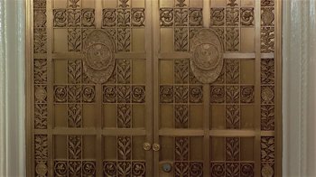 Movie still from “Suspect” (1987), directed by Peter Yates – The door of a building; Wide shot, Overhead angle