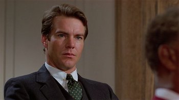 Movie still from “Suspect” (1987), directed by Peter Yates – A person wearing a suit and tie; Close Up shot, Low angle