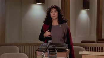 Movie still from “Suspect” (1987), directed by Peter Yates – A woman standing in front of a bunch of records; Medium shot, Low angle