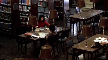 Movie still from “Suspect” (1987), directed by Peter Yates – Two people sitting at a table in a library; Wide shot, High angle