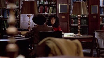Movie still from “Suspect” (1987), directed by Peter Yates – A woman sitting at a table in front of another woman; Medium shot, High angle