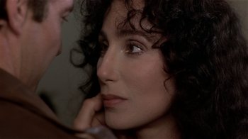 Movie still from “Suspect” (1987), directed by Peter Yates – A person with curly hair looking at the camera; Close Up shot, Over the shoulder angle
