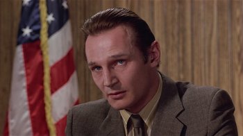 Movie still from “Suspect” (1987), directed by Peter Yates – A person wearing a suit and tie; Close Up shot, Low angle