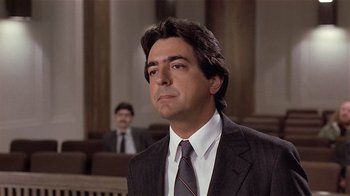 Movie still from “Suspect” (1987), directed by Peter Yates – A man wearing a suit and tie in a courtroom; Close Up shot, Low angle