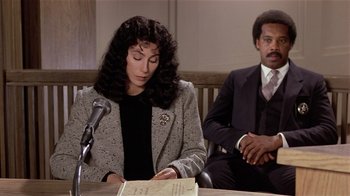 Movie still from “Suspect” (1987), directed by Peter Yates – A woman is sitting at a table and a man is sitting next to her; Medium shot, High angle