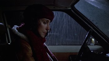 Movie still from “Suspect” (1987), directed by Peter Yates – A woman sitting in the driver's seat of a car in the rain; Close Up shot, Low angle