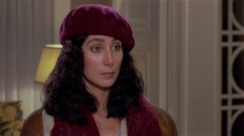 Movie still from “Suspect” (1987), directed by Peter Yates – A woman wearing a purple hat and a scarf; Close Up shot, High angle