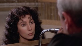 Movie still from “Suspect” (1987), directed by Peter Yates – A woman looking into a bathroom mirror in front of a sink; Close Up shot, Over the shoulder angle