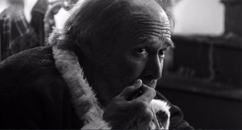 Movie still from “Sweet Thing” (2020), directed by Alexandre Rockwell – An old man with a beard is sitting in a room; Close Up shot, Low angle