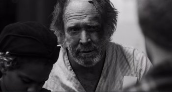 Movie still from “Sweet Thing” (2020), directed by Alexandre Rockwell – An older man with a beard and mustache; Close Up shot, Over the shoulder angle