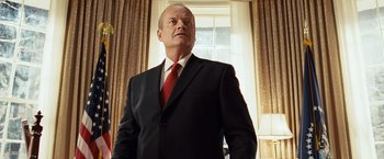 Movie still from “Swing Vote” (2008), directed by Joshua Michael Stern – A man in a black suit and a red tie; Medium shot, Low angle