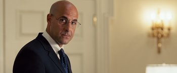 Movie still from “Swing Vote” (2008), directed by Joshua Michael Stern – A man in a suit and tie standing in front of a door; Close Up shot, Over the shoulder angle