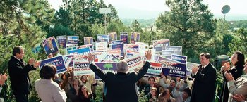 Movie still from “Swing Vote” (2008), directed by Joshua Michael Stern – A crowd of people are gathered in a park to hear a speech; Wide shot, High angle