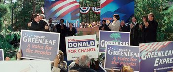 Movie still from “Swing Vote” (2008), directed by Joshua Michael Stern – A group of people holding up signs at a political event; Medium shot, High angle