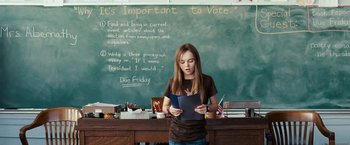 Movie still from “Swing Vote” (2008), directed by Joshua Michael Stern – A young girl standing in front of a chalkboard; Medium shot, High angle