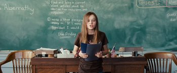 Movie still from “Swing Vote” (2008), directed by Joshua Michael Stern – A girl is holding a book in front of a chalkboard; Medium shot, High angle