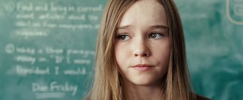 Movie still from “Swing Vote” (2008), directed by Joshua Michael Stern – A young girl with long blonde hair stares into the camera; Close Up shot, High angle