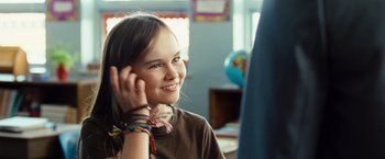 Movie still from “Swing Vote” (2008), directed by Joshua Michael Stern – A young girl wearing a brown shirt and a pair of colorful bracelets; Close Up shot, Over the shoulder angle