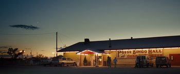 Movie still from “Swing Vote” (2008), directed by Joshua Michael Stern – People are standing in front of a restaurant at dusk; Extreme Wide shot, Low angle