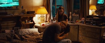 Movie still from “Swing Vote” (2008), directed by Joshua Michael Stern – A man and a woman sitting on a bed in front of a lamp; Medium shot, High angle