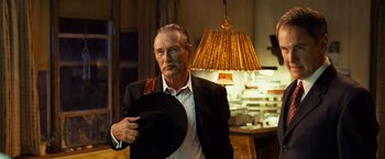 Movie still from “Swing Vote” (2008), directed by Joshua Michael Stern – An older man in a black suit and a black hat; Medium shot, Low angle