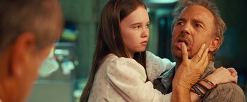 Movie still from “Swing Vote” (2008), directed by Joshua Michael Stern – A young girl with long brown hair is looking at the camera; Close Up shot, Over the shoulder angle