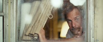 Movie still from “Swing Vote” (2008), directed by Joshua Michael Stern – A man holding a curtain in front of a window; Close Up shot, Low angle