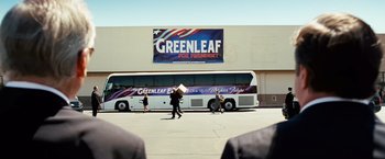 Movie still from “Swing Vote” (2008), directed by Joshua Michael Stern – People walking in front of a bus in a parking lot; Wide shot, Over the shoulder angle