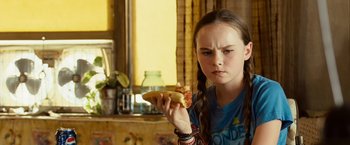 Movie still from “Swing Vote” (2008), directed by Joshua Michael Stern – A young girl holding a piece of pizza in her hand; Close Up shot, Over the shoulder angle
