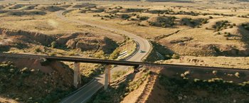 Movie still from “Swing Vote” (2008), directed by Joshua Michael Stern – An aerial view of a highway and a bridge in the middle of the desert; Extreme Wide shot, High angle