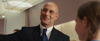 Movie still from “Swing Vote” (2008), directed by Joshua Michael Stern – A man in a suit and tie smiling for the camera; Close Up shot, Low angle