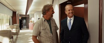 Movie still from “Swing Vote” (2008), directed by Joshua Michael Stern – Two men in business suits laughing in a hallway; Medium shot, Over the shoulder angle