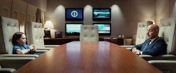 Movie still from “Swing Vote” (2008), directed by Joshua Michael Stern – A wooden table in front of a wall with three monitors; Wide shot, High angle