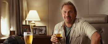 Movie still from “Swing Vote” (2008), directed by Joshua Michael Stern – A man holding a glass of beer in his right hand; Close Up shot, Over the shoulder angle