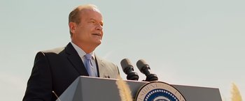 Movie still from “Swing Vote” (2008), directed by Joshua Michael Stern – A man standing at a podium with two microphones; Close Up shot, Low angle