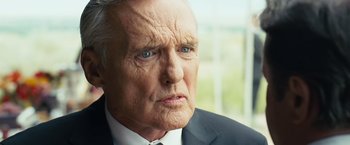 Movie still from “Swing Vote” (2008), directed by Joshua Michael Stern – An older man wearing a suit and tie; Close Up shot, Over the shoulder angle