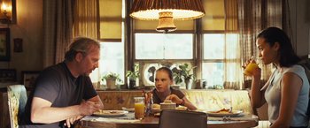 Movie still from “Swing Vote” (2008), directed by Joshua Michael Stern – A man and a woman sitting at a table with plates of food in front of them; Medium shot, Over the shoulder angle