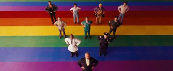 Movie still from “Swing Vote” (2008), directed by Joshua Michael Stern – A group of people standing on top of a rainbow colored floor; Wide shot, Overhead angle